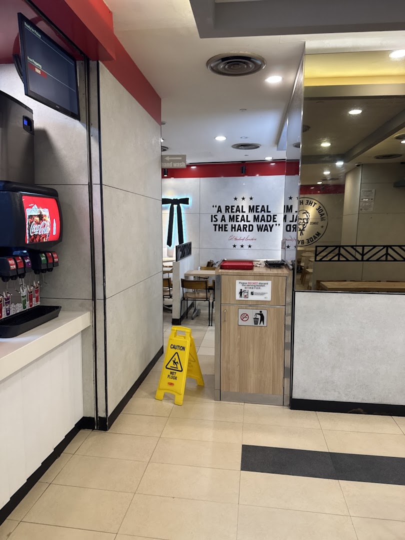 Interior view of KFC Clementi Mall, showing a self-serve drink station and dining area entrance.
