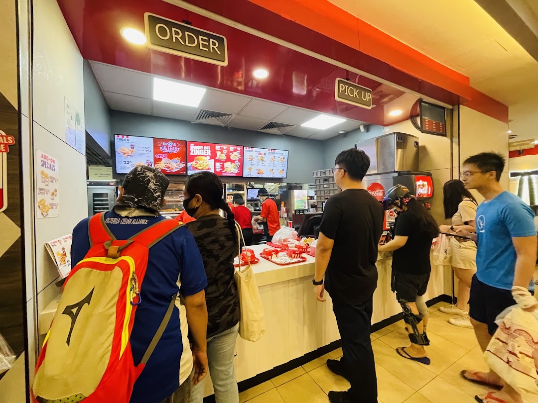 Customers queueing at the order and pick-up counter inside KFC Clementi Mall.