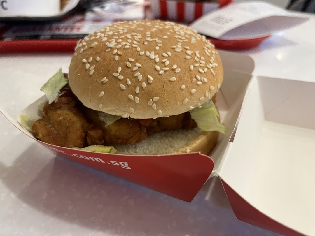 A delicious KFC chicken burger with lettuce and sesame bun in its signature red box.
