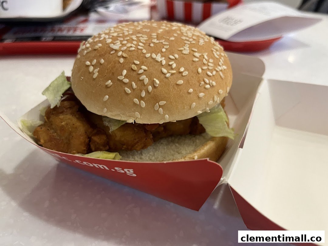 A delicious KFC chicken burger with lettuce and sesame bun in its signature red box.