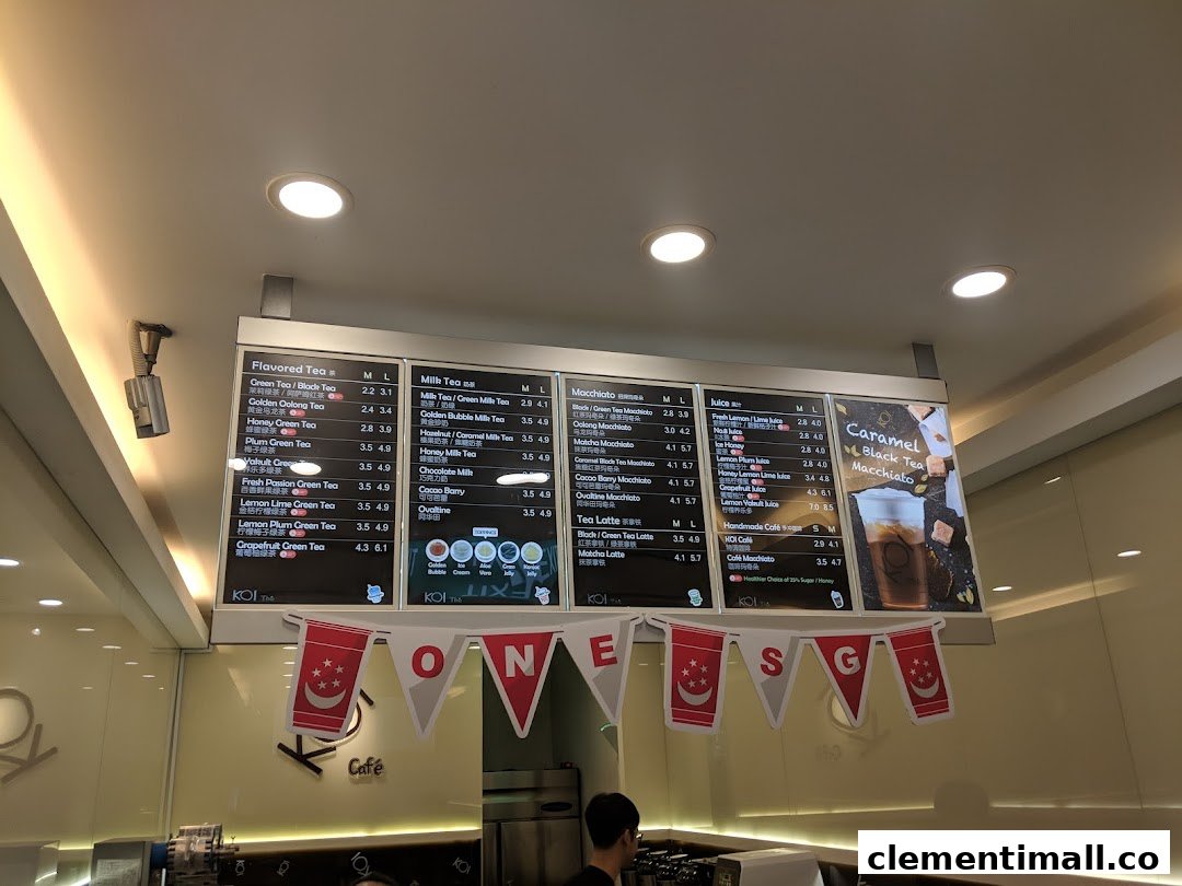 A large digital menu board displaying various tea and juice options at KOI Thé.