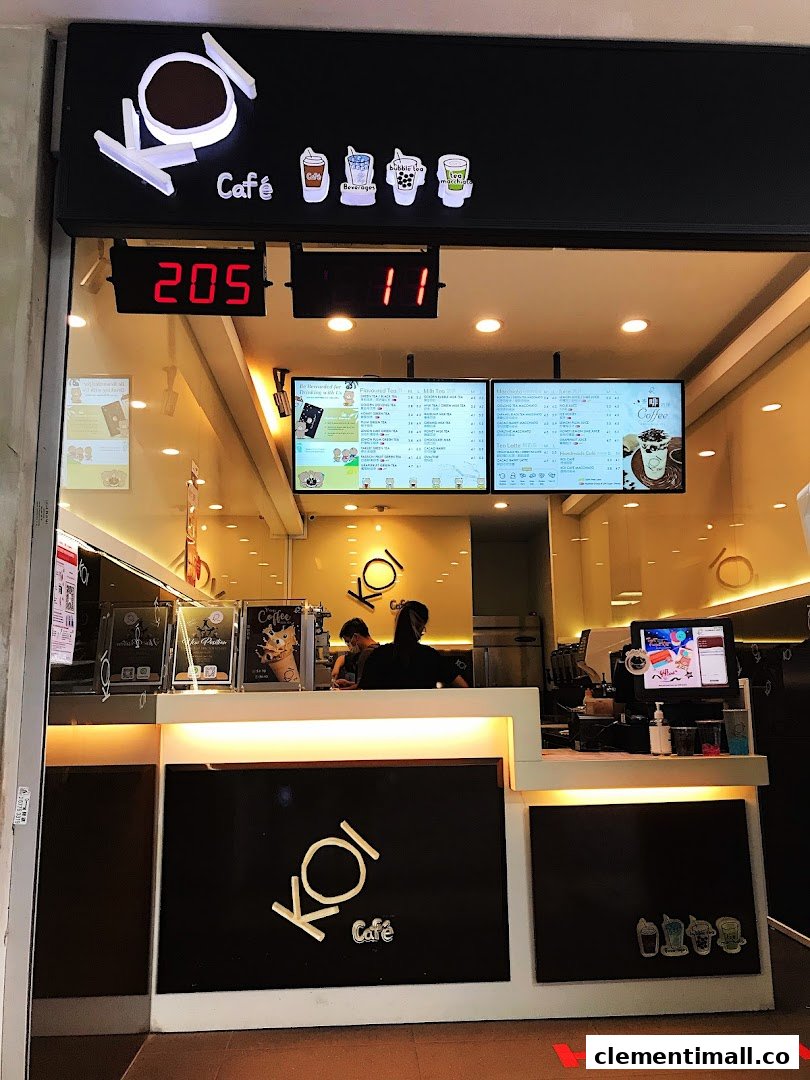 A view of KOI Thé Clementi Mall's counter area with staff and digital menu boards.