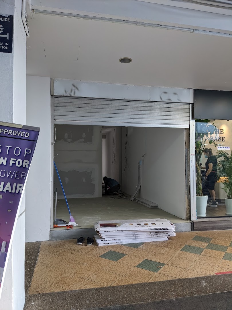 The entrance of KOI Thé Clementi Mall undergoing renovation, with a worker inside.