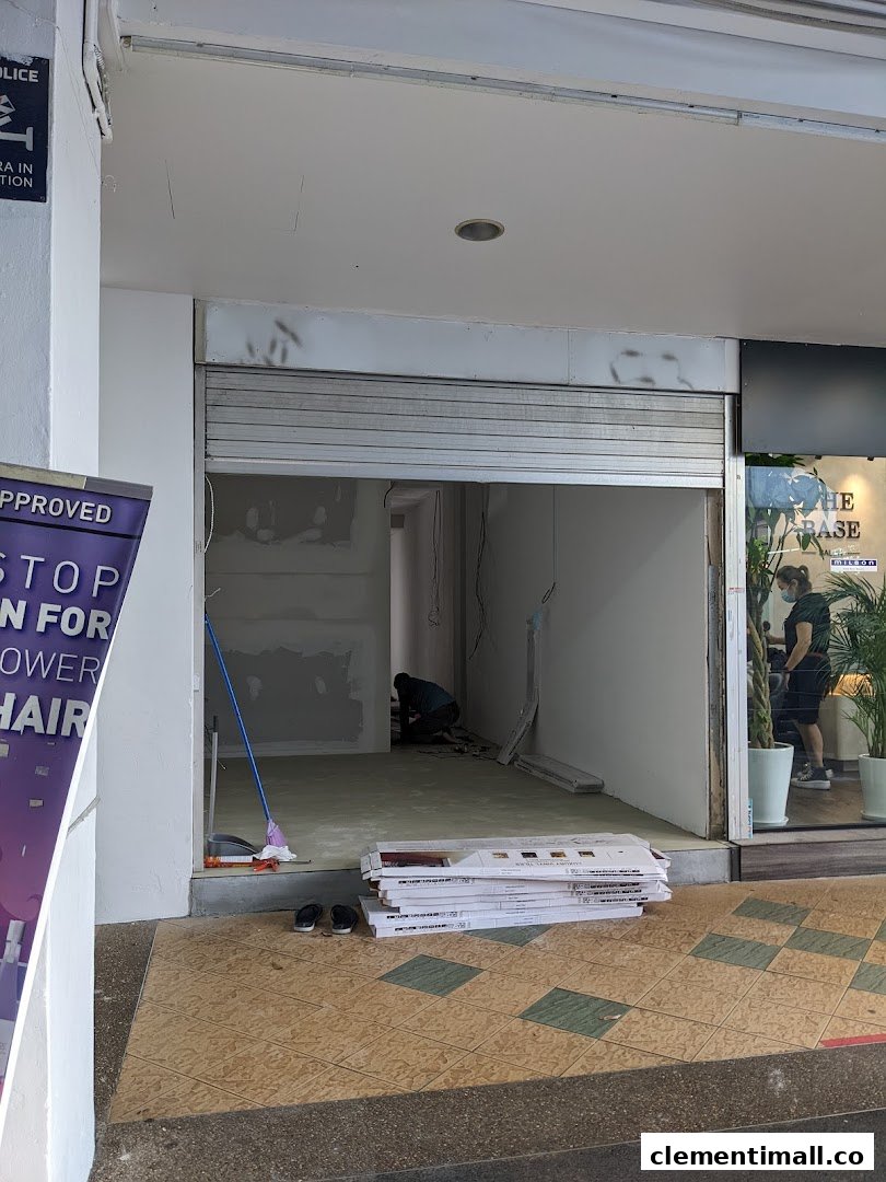 The entrance of KOI Thé Clementi Mall undergoing renovation, with a worker inside.