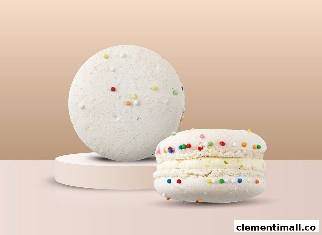 Two white macarons with colorful sprinkles, one on a pedestal, against a light background.