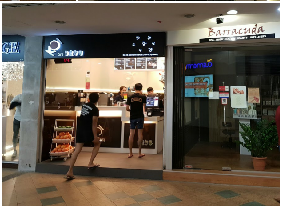 The bustling front of Cafe Q, a beverage shop, alongside Barracuda, a beauty and wellness center.