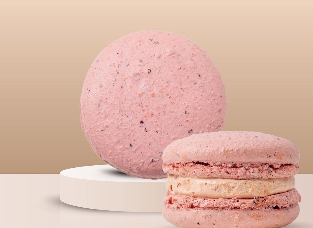 Two pink, textured confectionery items, one resembling a macaron, on a minimalist background.
