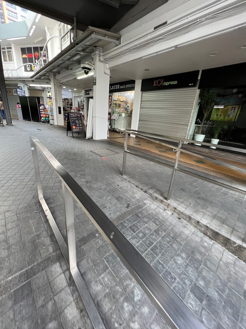Exterior view of KOI express at Clementi Mall, showing its closed storefront and adjacent shops along a walkway.