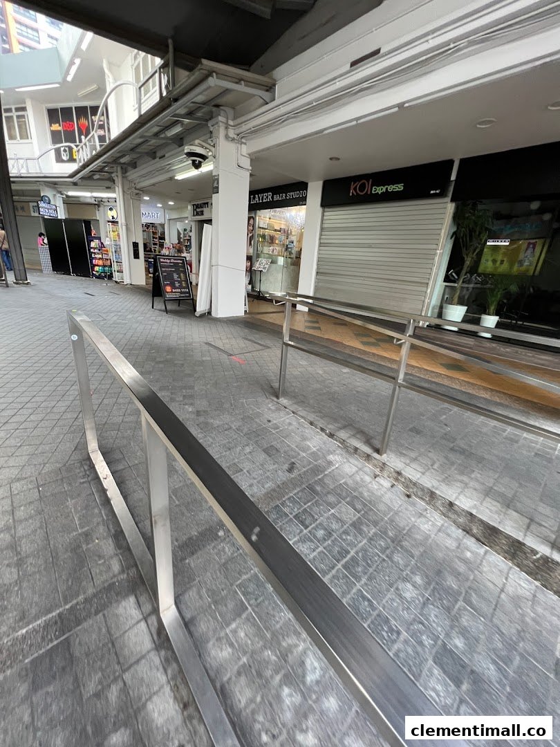 Exterior view of KOI express at Clementi Mall, showing its closed storefront and adjacent shops along a walkway.