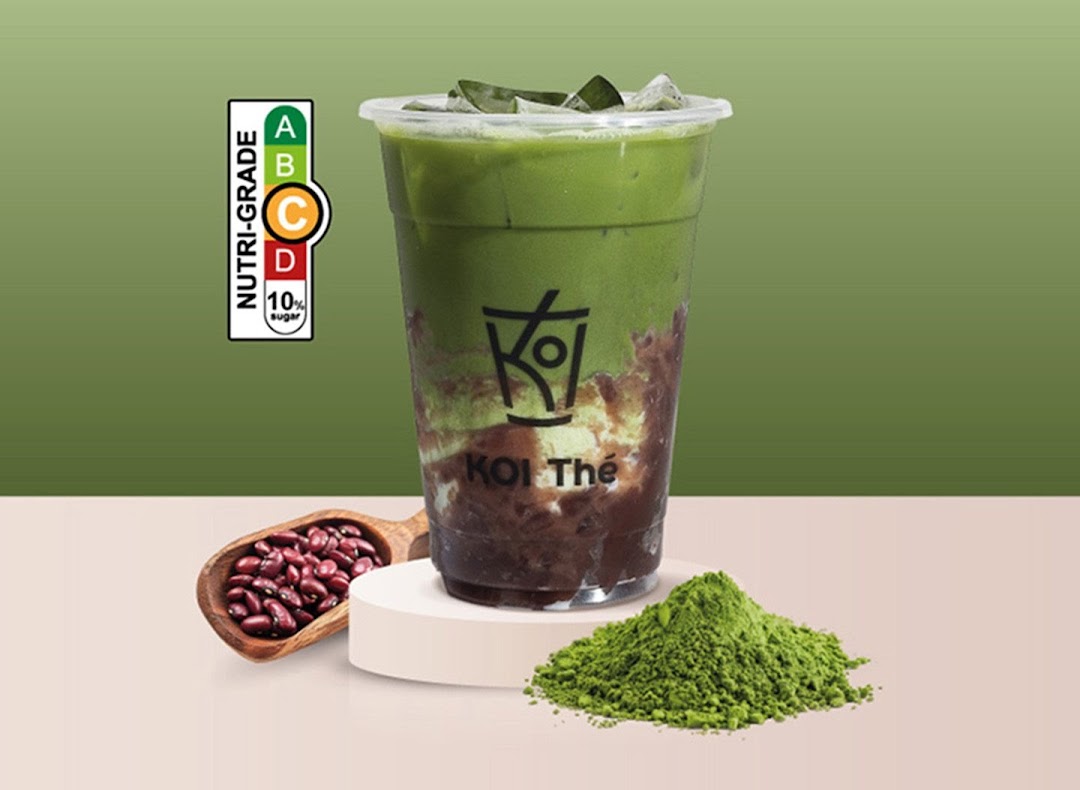 A vibrant KOI Thé matcha drink with red beans, matcha powder, and a nutri-grade C label.