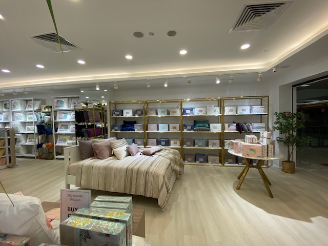 Interior view of KOMME, showcasing stylish bedding, pillows, and home essentials on display.