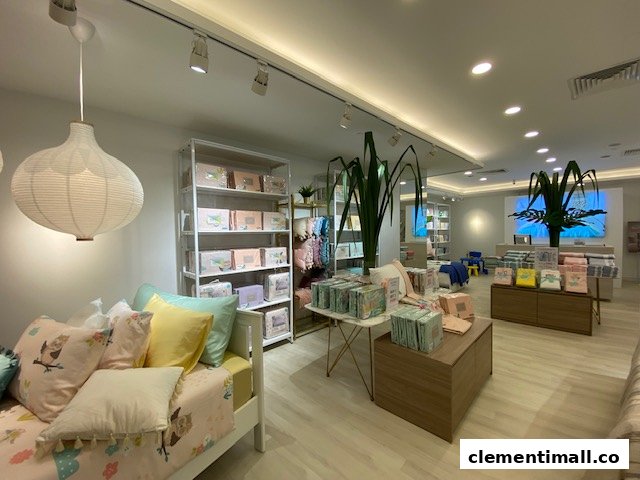 Interior view of KOMME, a home furnishings store, showcasing bedding, pillows, and decorative items in a bright setting.