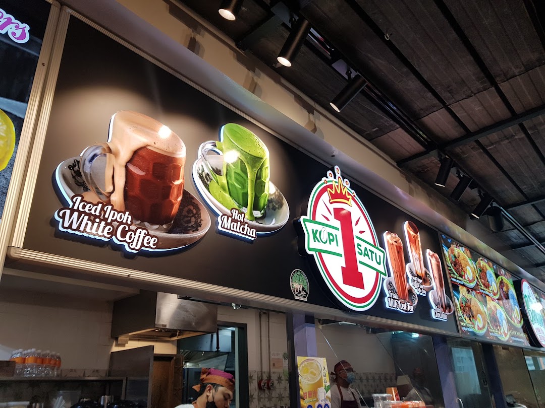 Illuminated signage of Kopi Satu featuring Iced Ipoh White Coffee and Hot Matcha visuals above a service counter.
