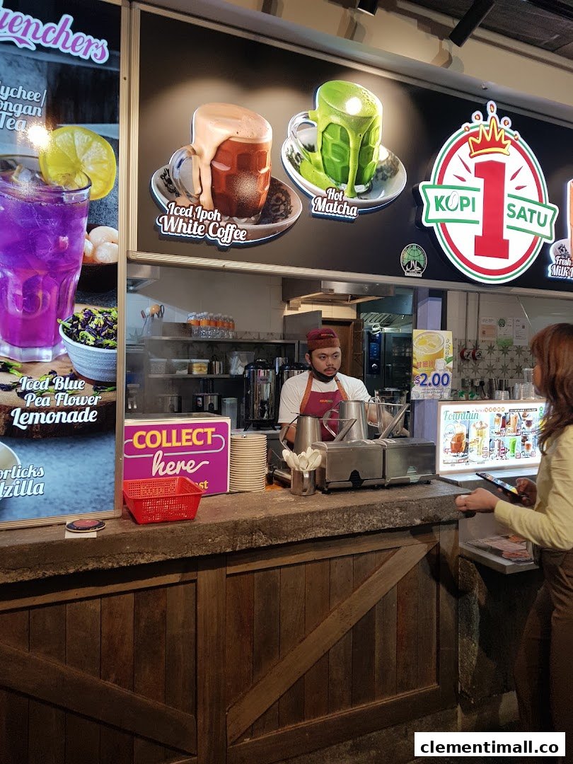 A staff member serves customers at the Kopi Satu counter, featuring vibrant drink displays.