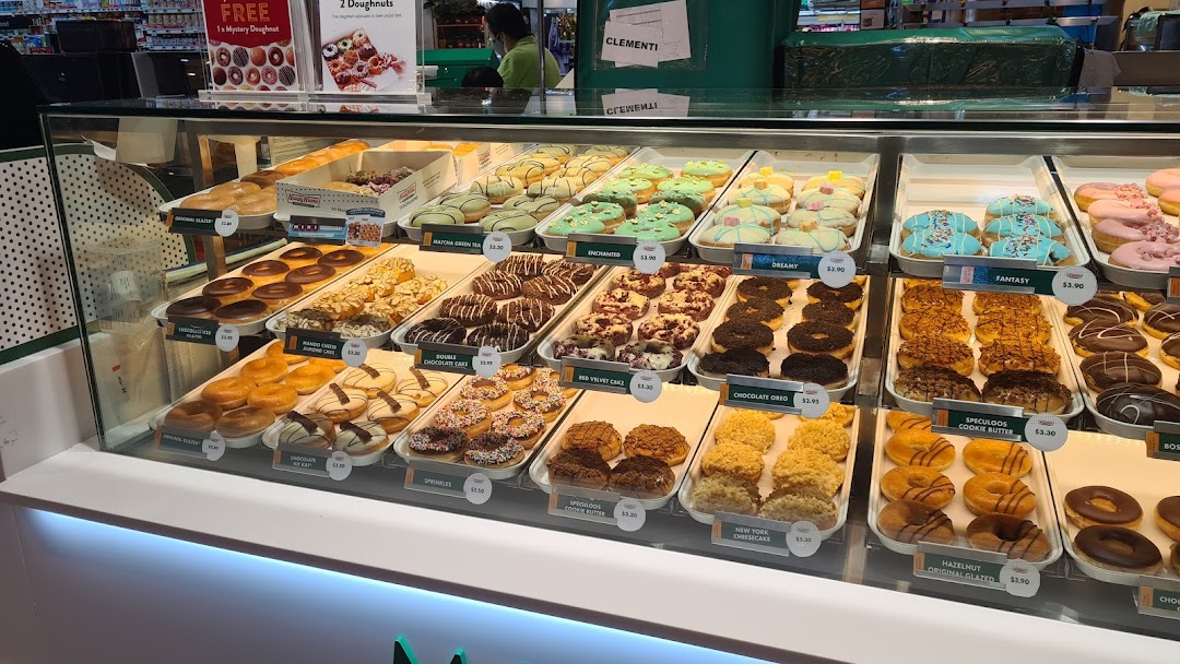 A vibrant display case showcasing a wide variety of Krispy Kreme doughnuts.