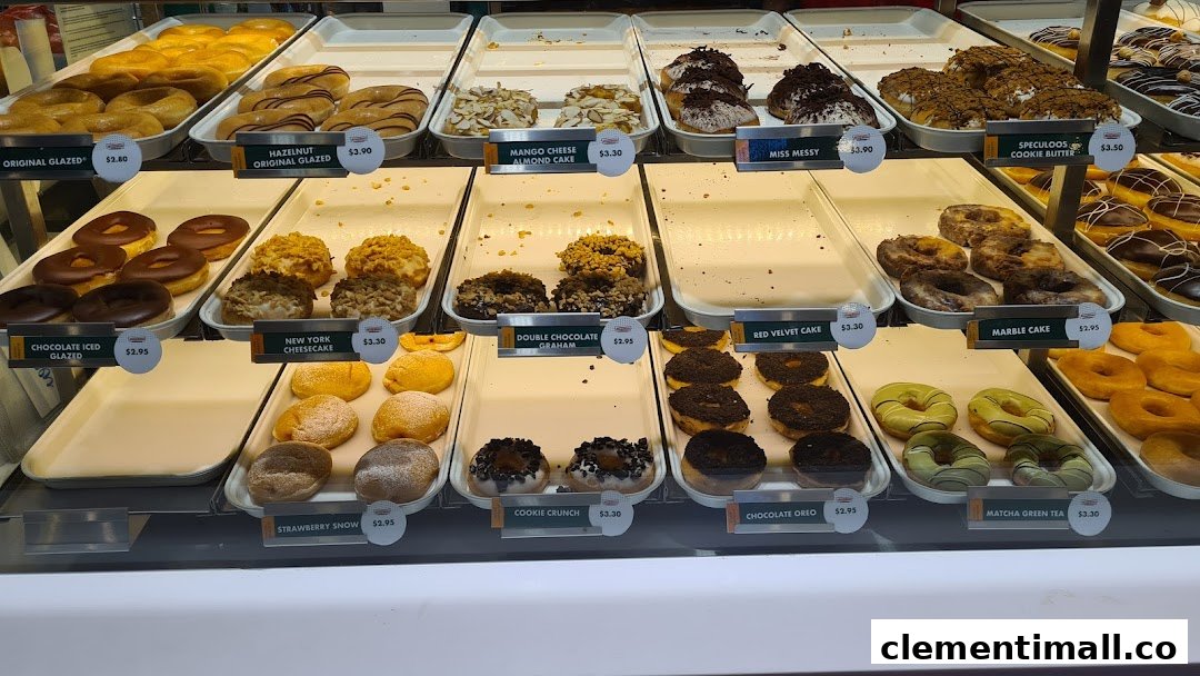 A vibrant display case showcasing a variety of Krispy Kreme donuts with their names and prices.