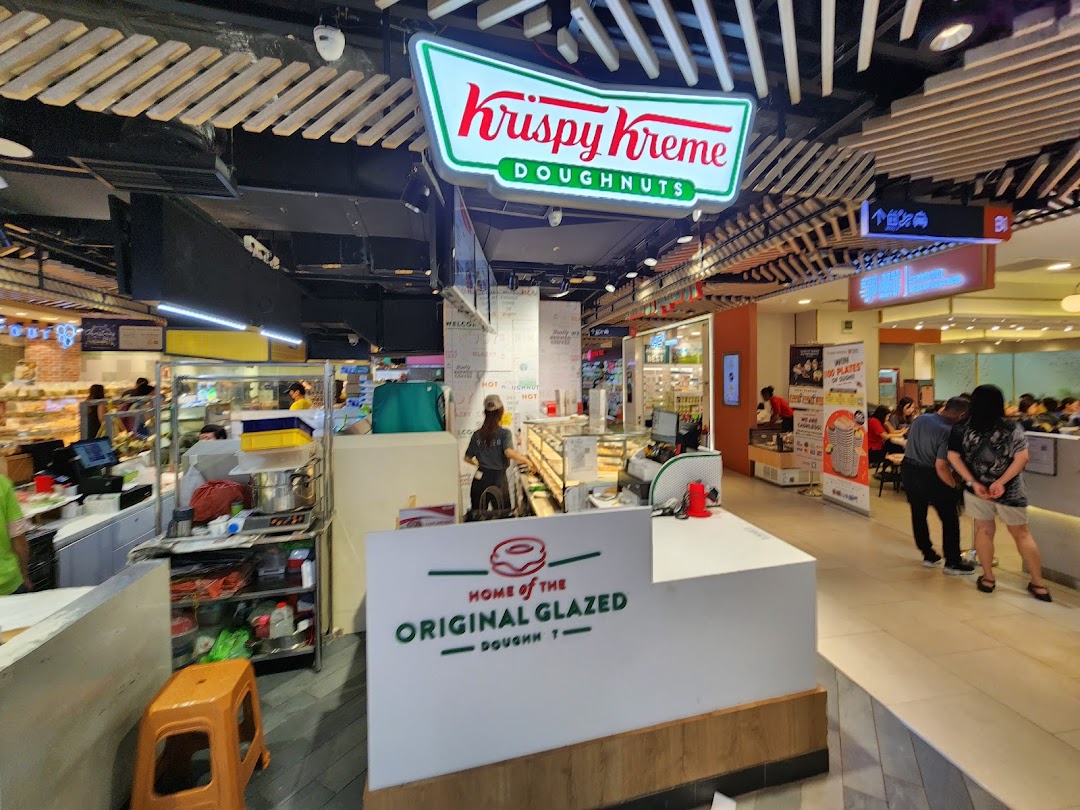 A view of the Krispy Kreme counter and staff, showcasing the doughnut preparation area within the mall.