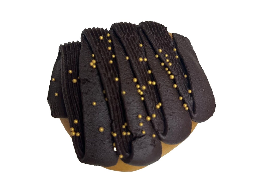A Krispy Kreme donut featuring rich chocolate frosting and shimmering golden sprinkles.