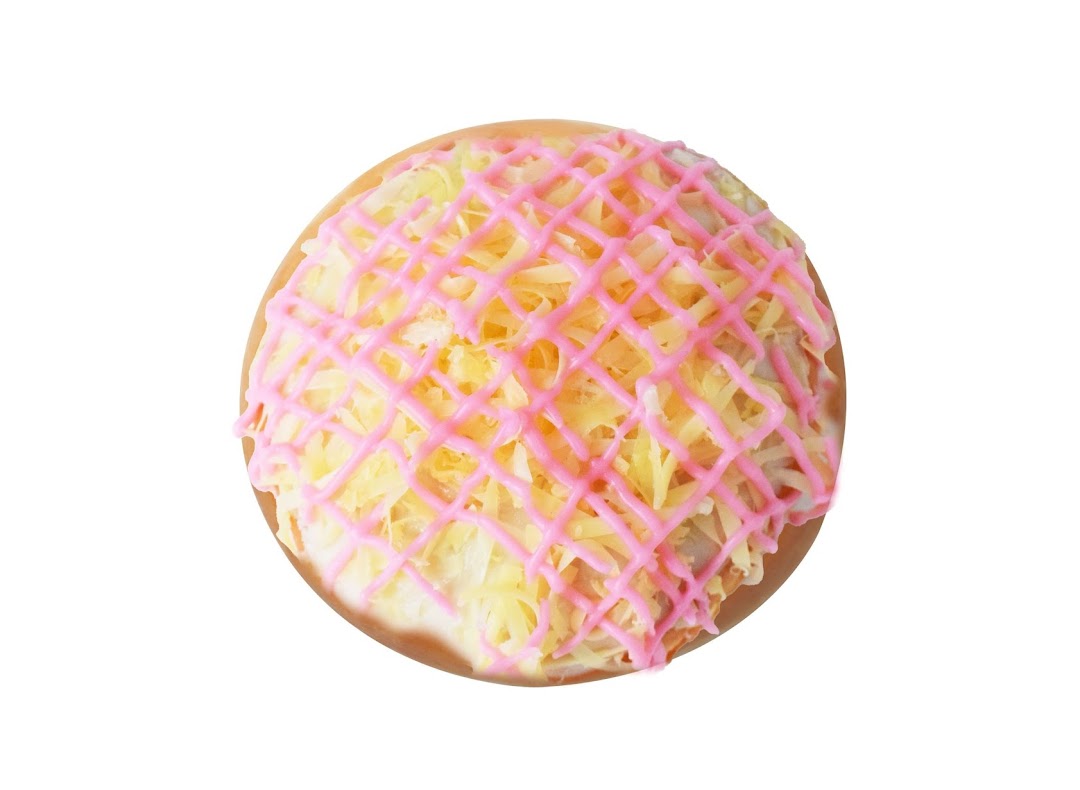 A Krispy Kreme donut featuring pink lattice icing and yellow shredded toppings.