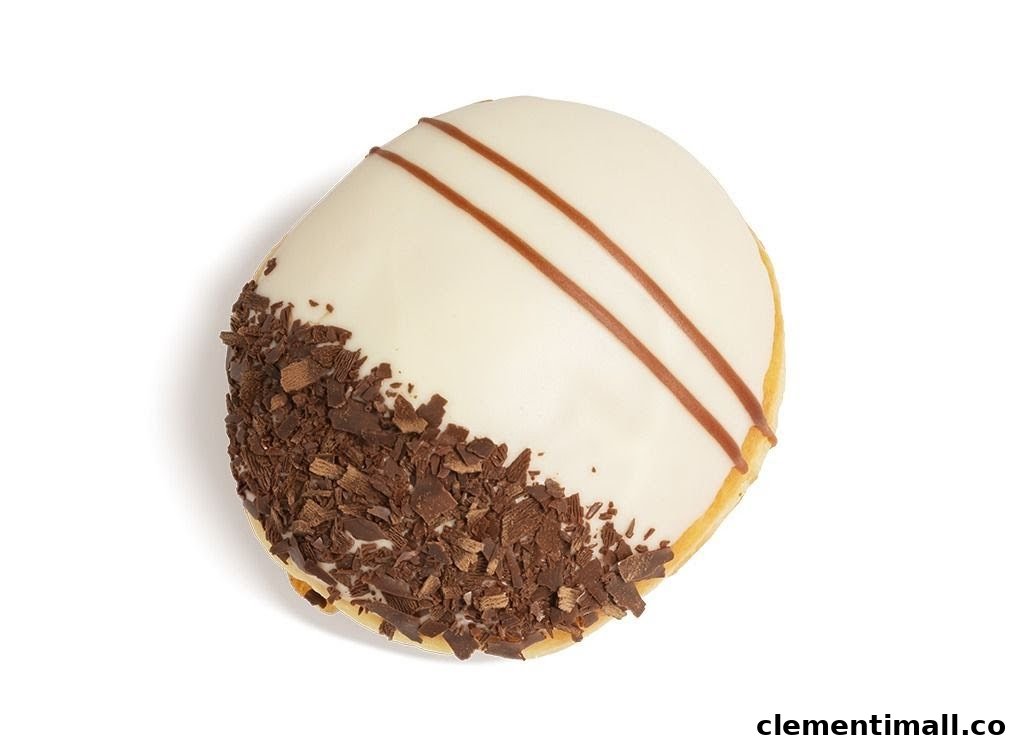 A delicious Krispy Kreme donut with white icing, chocolate shavings, and brown stripes.