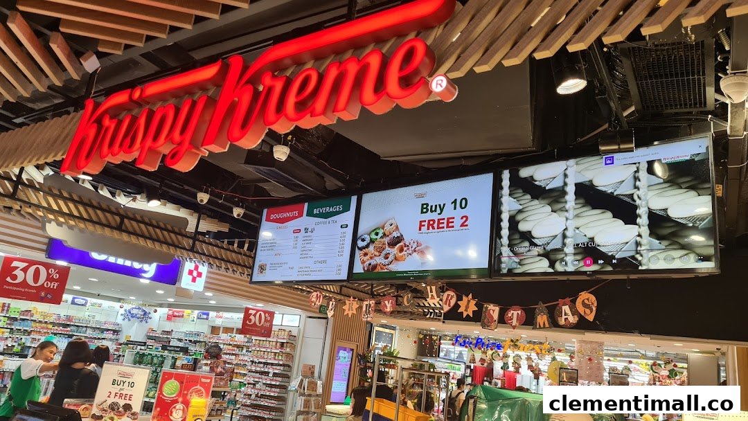 Interior view of Krispy Kreme with prominent signage and digital menu boards displaying doughnuts and beverages.