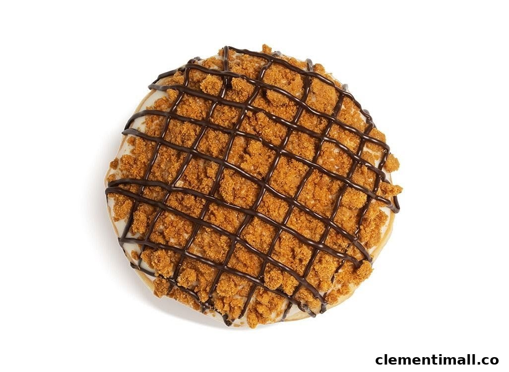 A delicious Krispy Kreme donut topped with cookie crumbs and chocolate drizzle.