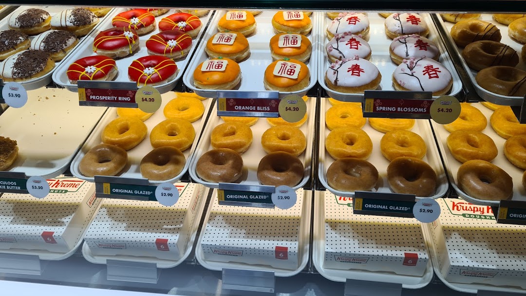 A vibrant display of various Krispy Kreme donuts, including seasonal and classic glazed options.