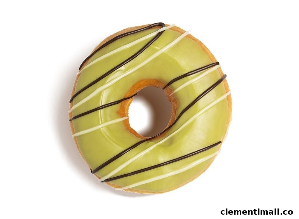 A vibrant green-glazed Krispy Kreme donut with white and dark chocolate drizzles.