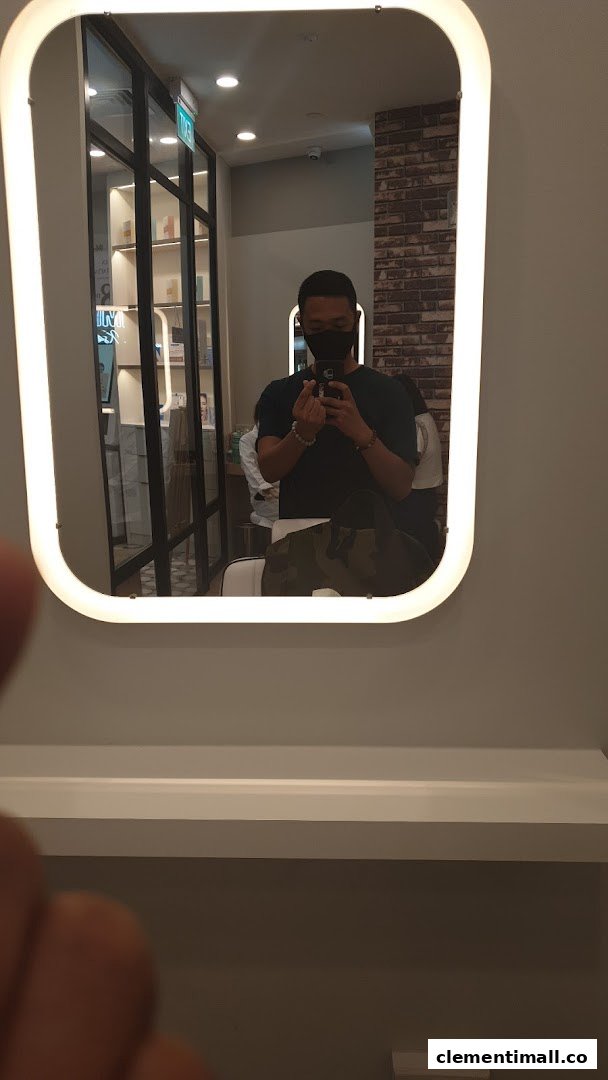 A person taking a mirror selfie inside Kskin, showing the modern interior with product displays.