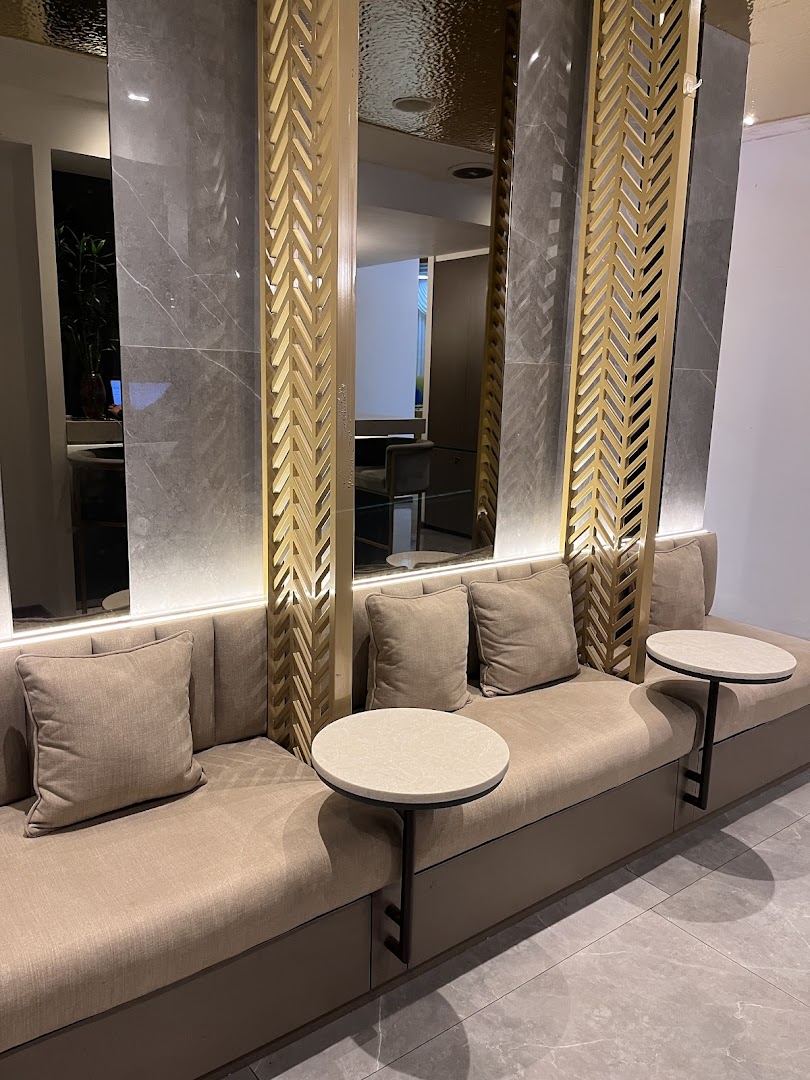 A cozy seating area with plush benches, small tables, and elegant gold and marble decor.