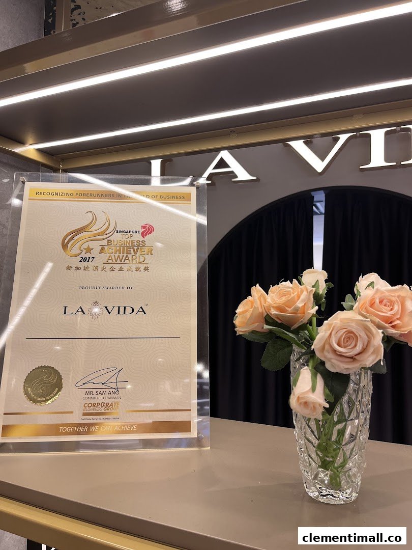 An award certificate for La Vida and a vase of flowers displayed on a counter.