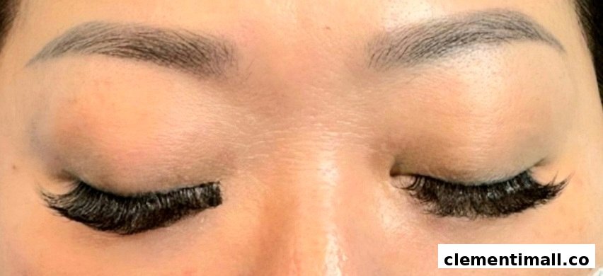 Close-up of a person's eyes showcasing eyelash extensions, with one eye partially done.