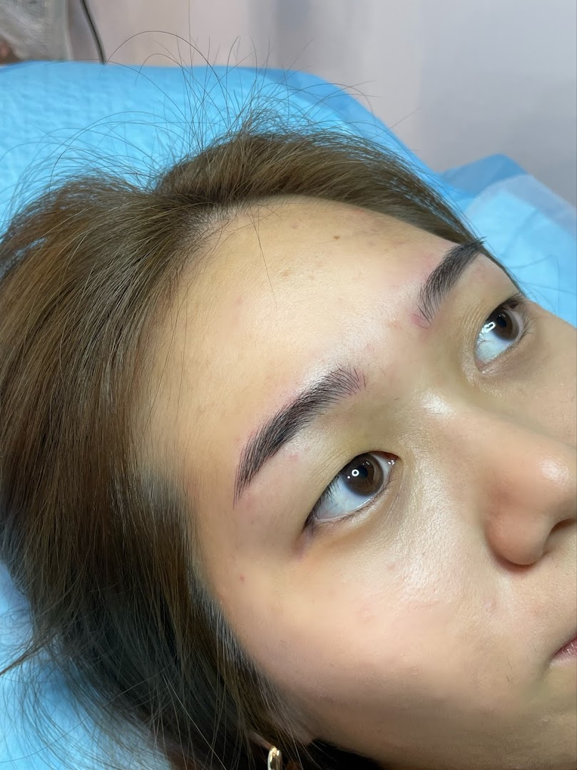 Close-up of a person's face showcasing freshly done eyebrows on a treatment bed.