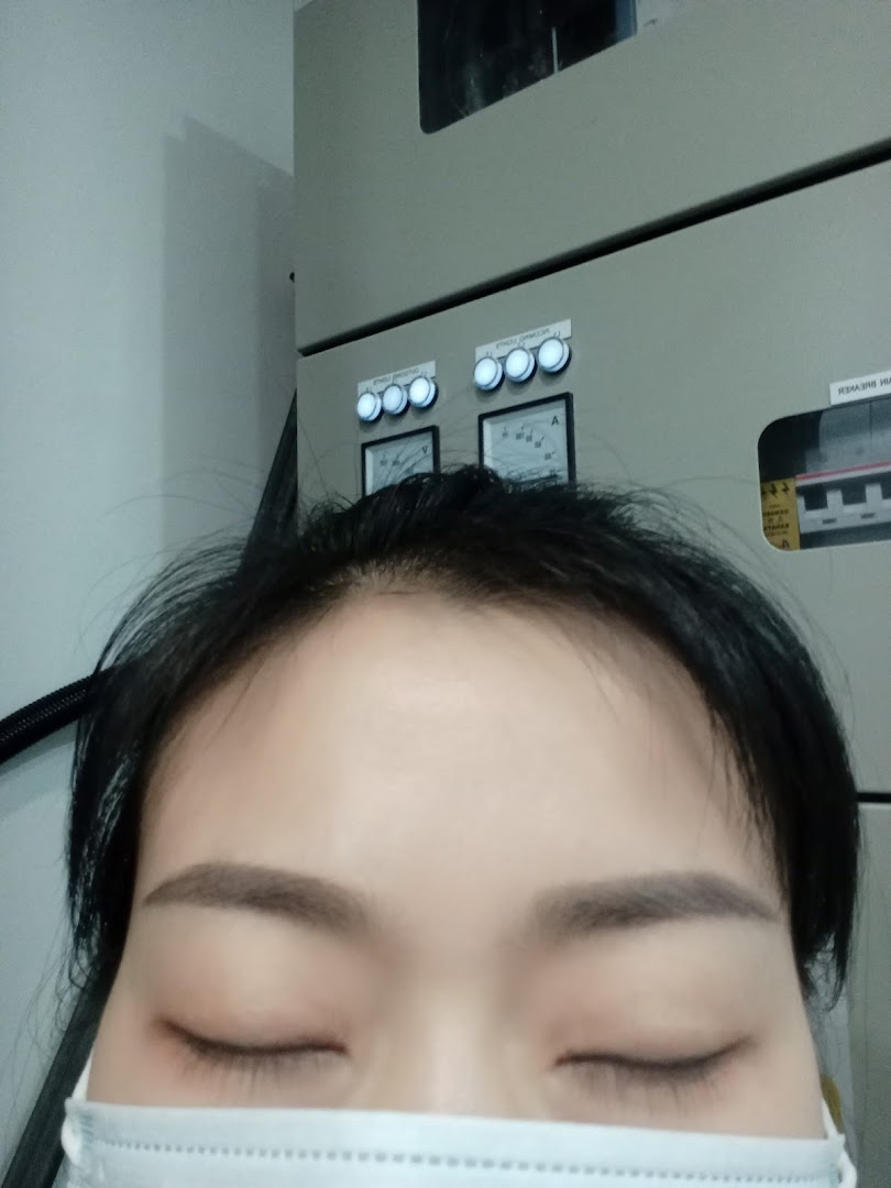 A very close-up shot of a person's face with closed eyes and a mask, against an industrial background.