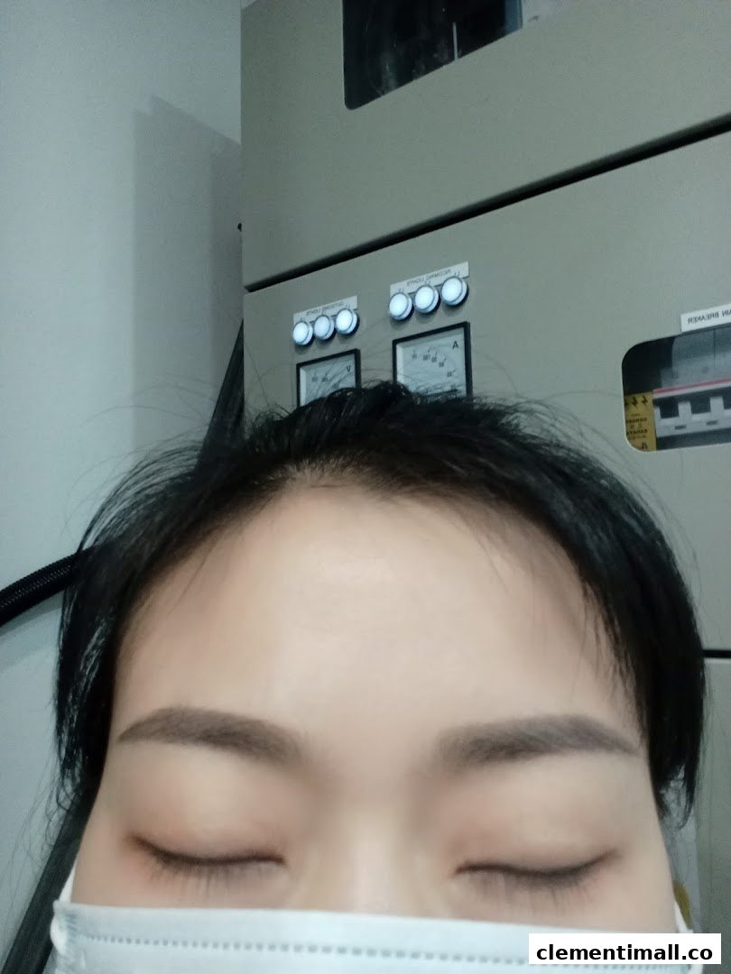 A very close-up shot of a person's face with closed eyes and a mask, against an industrial background.