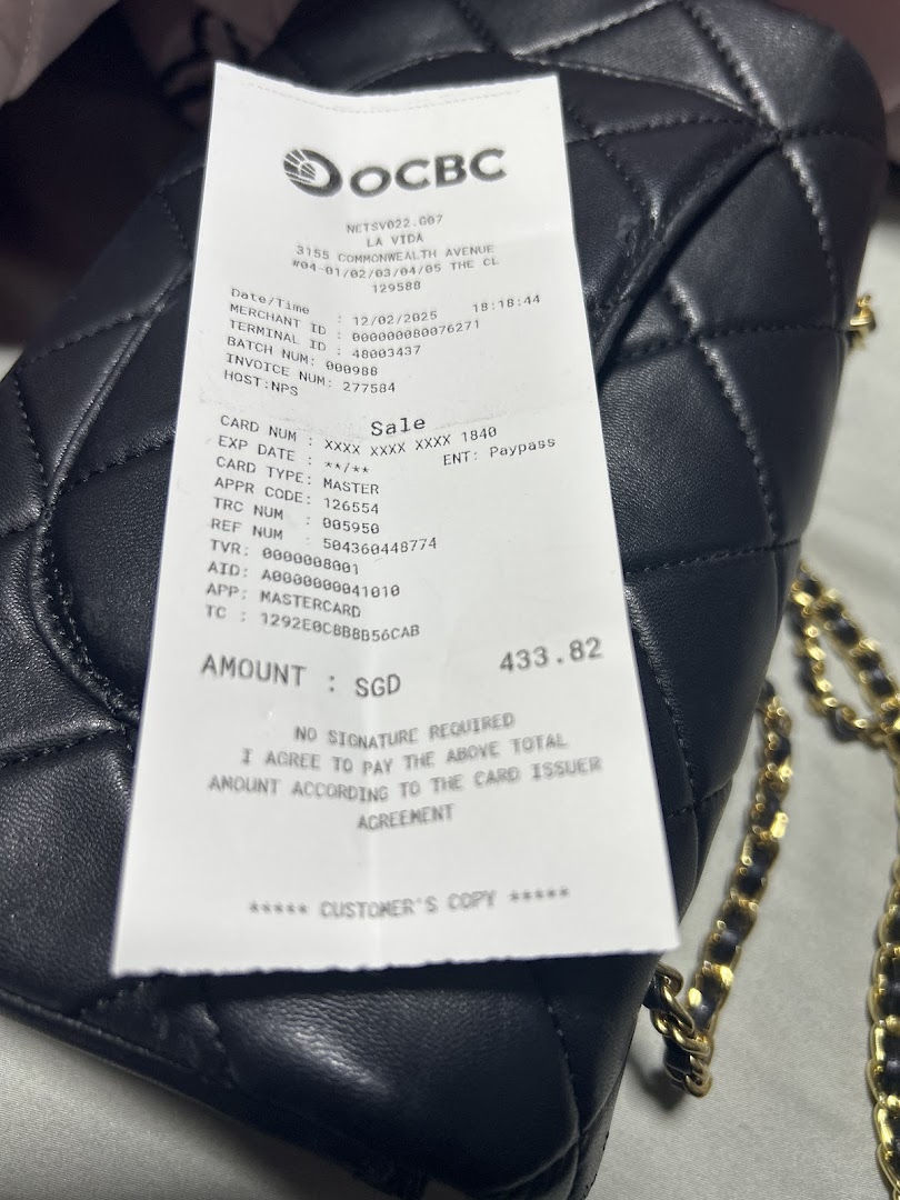 A detailed payment receipt from La Vida displayed on a stylish black quilted handbag.