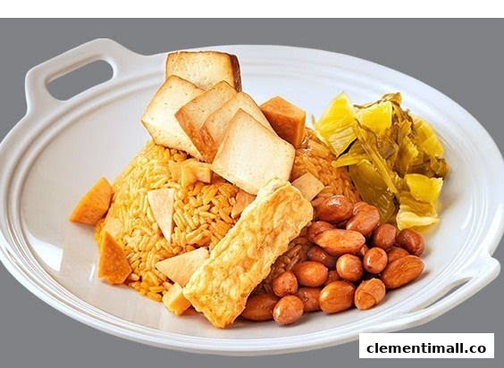 A hearty plate featuring rice, peanuts, pickled vegetables, and fried tofu/bread on a white dish.
