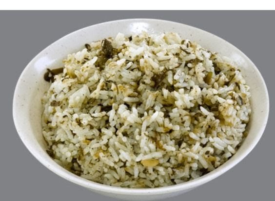 A close-up of a bowl of fragrant mixed rice, possibly with herbs or preserved vegetables.