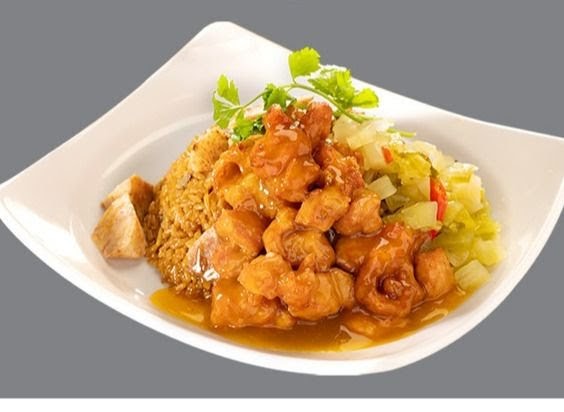 A delicious plate featuring golden fried chicken in sauce, fried rice, and pickled vegetables.