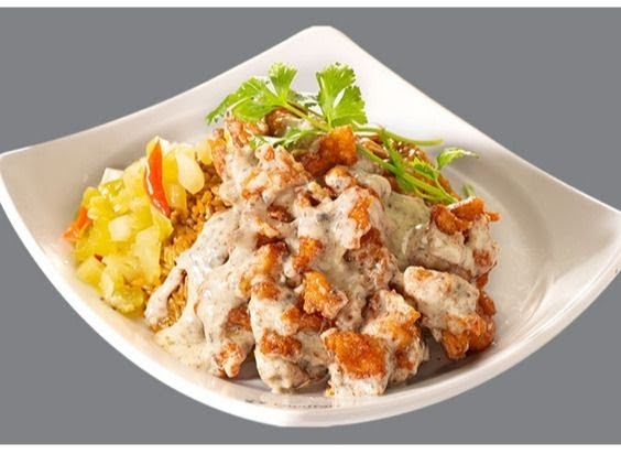 A plate of crispy fried chicken or pork pieces coated in a creamy sauce, served with rice and pickled vegetables.