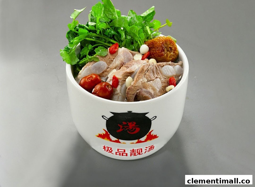 A white bowl filled with herbal soup, pork ribs, red dates, goji berries, and fresh greens.