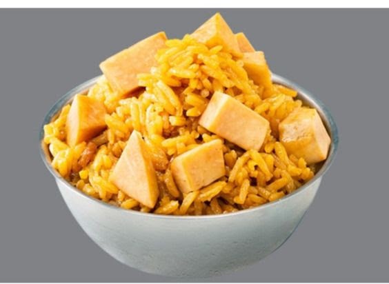 A close-up of a bowl of yellow rice with cubed sweet potato or pumpkin.