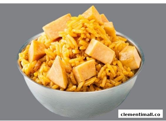 A close-up of a bowl of yellow rice with cubed sweet potato or pumpkin.