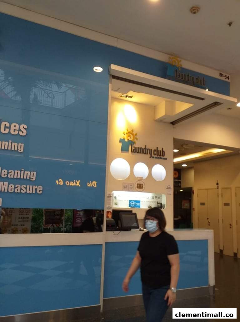 The Laundry Club shop front with blue and white decor, signage, and a person walking by.