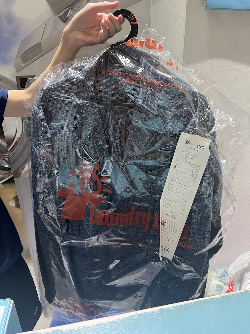 A customer collects a freshly laundered garment, neatly packed and ready to wear from Laundry Club.