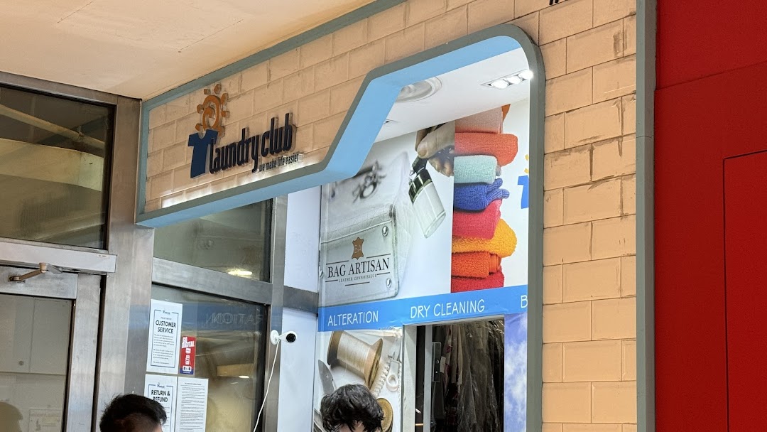 The exterior of Laundry Club, a modern laundry and dry cleaning service with a bright facade.
