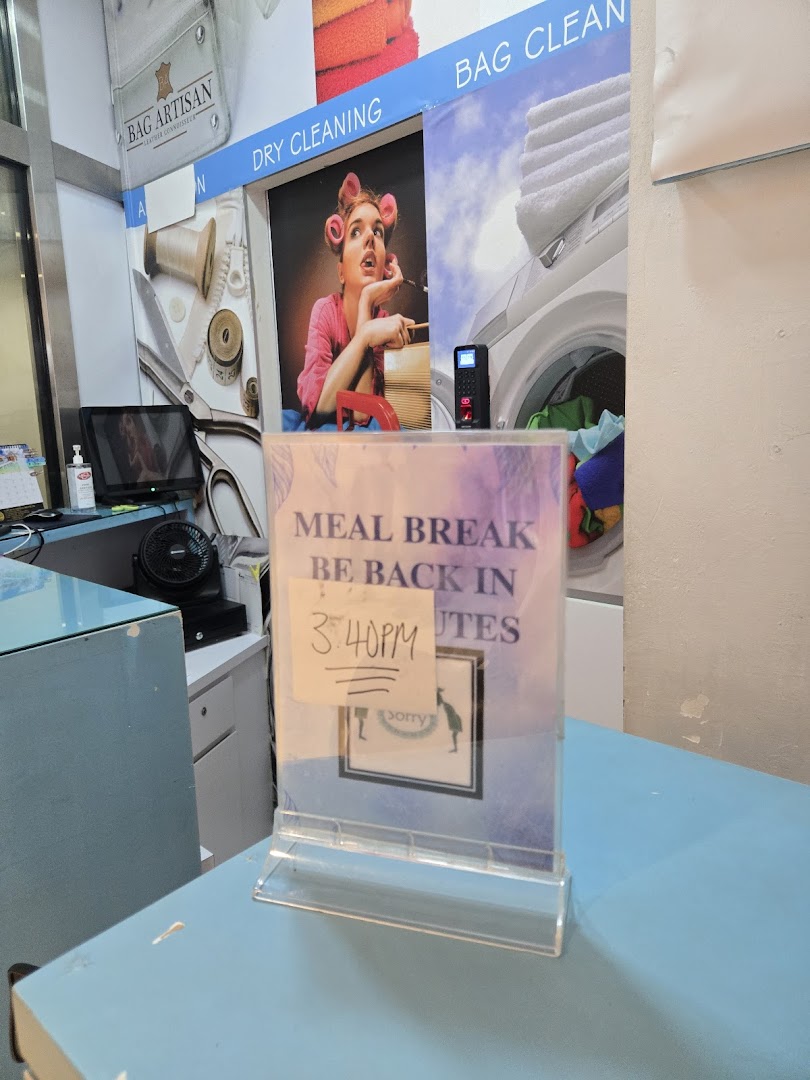 Interior view of Laundry Club's counter, featuring service signs and a temporary 'Meal Break' notice.