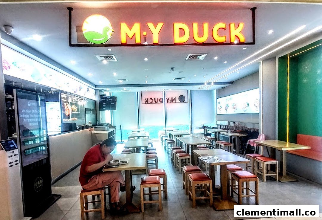 Interior view of M.Y Duck restaurant with seating, a counter, and a customer dining.