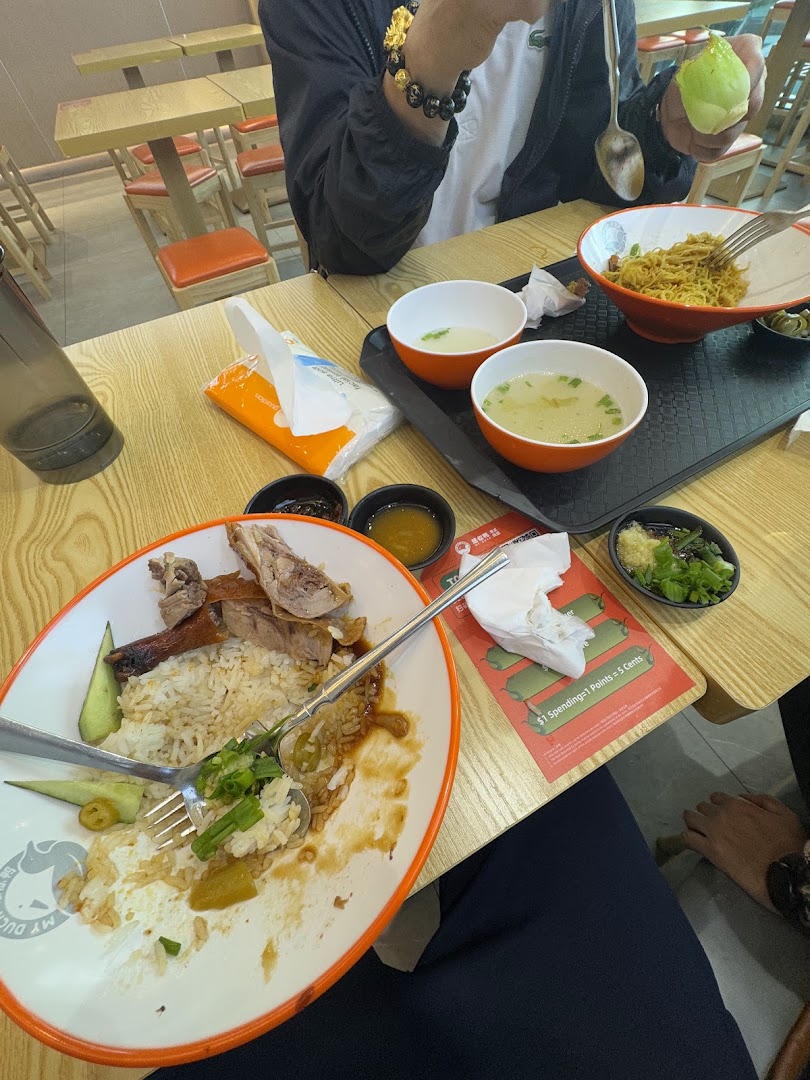 A table with partially eaten duck rice, noodles, and soup at M.Y Duck restaurant.