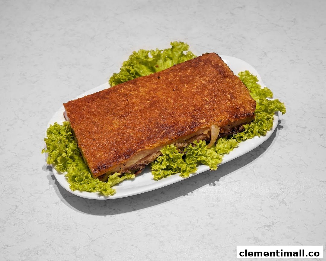 A large, rectangular piece of crispy roasted pork belly served on a bed of fresh green lettuce.